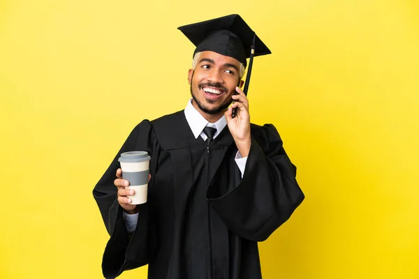 Junger Kolumbianischer Universitätsabsolvent Isoliert Auf Gelbem Hintergrund Mit Kaffee Zum — Stockfoto