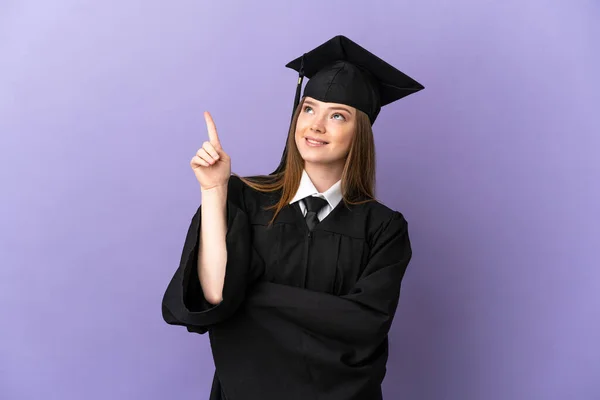 Joven Graduado Universitario Sobre Fondo Púrpura Aislado Apuntando Una Gran — Foto de Stock