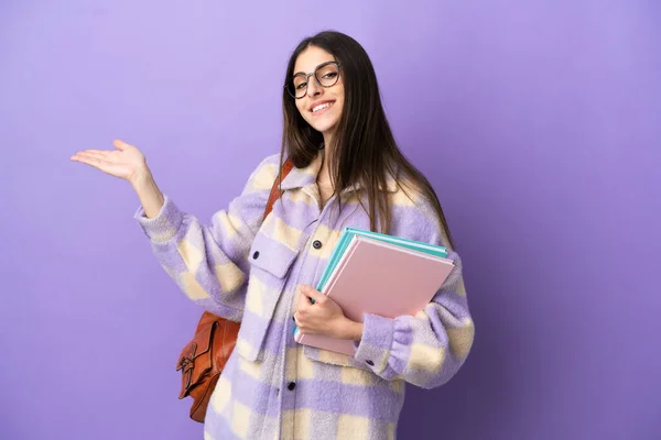 Jovem Estudante Mulher Isolada Fundo Roxo Estendendo Mãos Para Lado — Fotografia de Stock