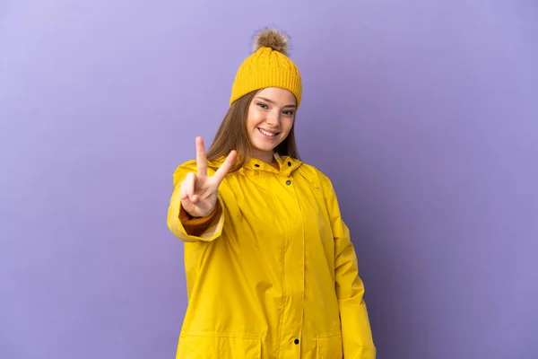 Chica Adolescente Con Abrigo Impermeable Sobre Fondo Púrpura Aislado Sonriendo —  Fotos de Stock