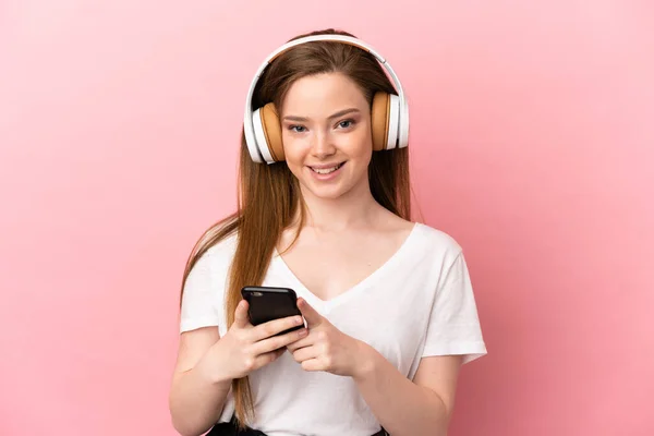 Menina Adolescente Sobre Fundo Rosa Isolado Ouvindo Música Com Celular — Fotografia de Stock