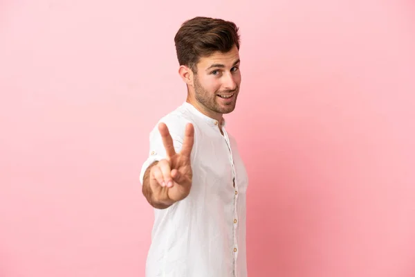 Joven Hombre Guapo Caucásico Aislado Sobre Fondo Rosa Sonriendo Mostrando —  Fotos de Stock