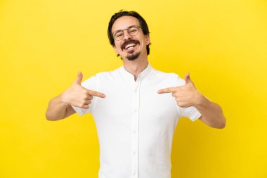 Sarı arka planda soyutlanmış, gururlu ve kendini beğenmiş beyaz bir genç.