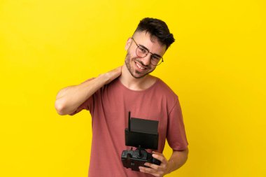 Sarı arka planda uzaktan kumandalı uzaktan kumandalı bir adam gülüyor.