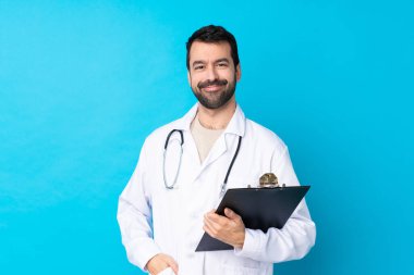 Kafkas kökenli genç bir adam. Doktor önlüğü giymiş ve elinde bir klasör var.