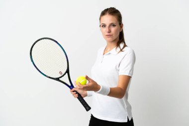 Beyaz arka planda tenis oynayan beyaz tenli genç kadın.