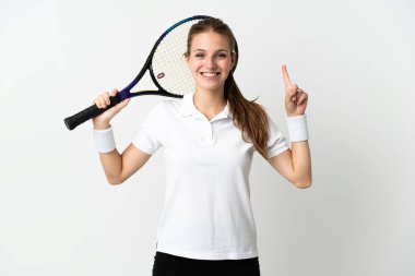 Beyaz arka planda izole genç beyaz kadın tenis oynuyor ve yukarı işaret ediyor