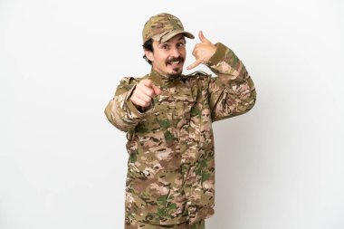 Beyaz arka planda izole edilmiş asker telefon hareketi yapıyor ve ön tarafı işaret ediyor.