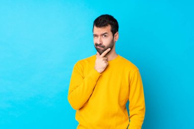 İzole edilmiş mavi arka planı olan genç beyaz bir adam.