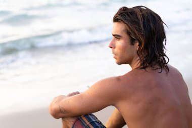 Genç beyaz adam denize dalmaya hazırlanıyor.