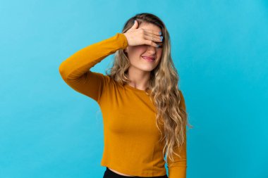 Genç Brezilyalı bir kadın mavi arka planda izole edilmiş, yorgun ve hasta bir ifadeyle.