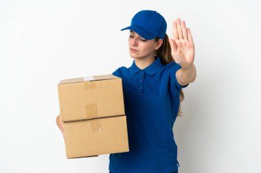 Beyaz arka planda izole edilmiş genç teslimatçı kadın dur hareketi yapıyor ve hayal kırıklığına uğruyor