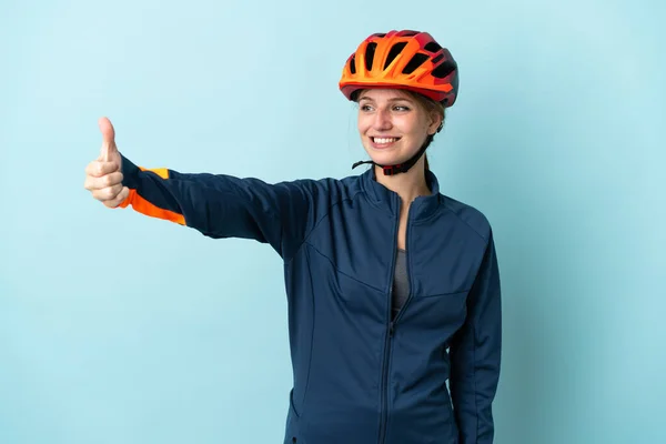 Молодая Женщина Велосипедистка Изолированная Синем Фоне Показывает Большой Палец Вверх — стоковое фото