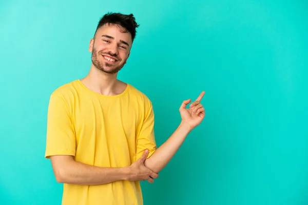 Jovem Caucasiano Isolado Fundo Azul Apontando Dedo Para Lado — Fotografia de Stock