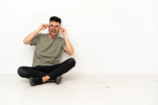 Jonge Blanke Man Zit Vloer Geïsoleerd Witte Achtergrond Met Een — Stockfoto