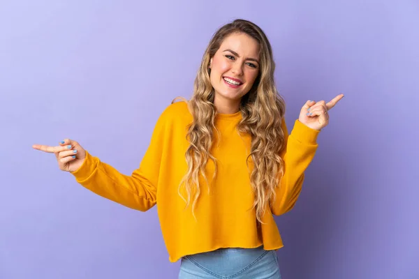 Jovem Brasileira Isolada Fundo Roxo Apontando Dedo Para Laterais Feliz — Fotografia de Stock