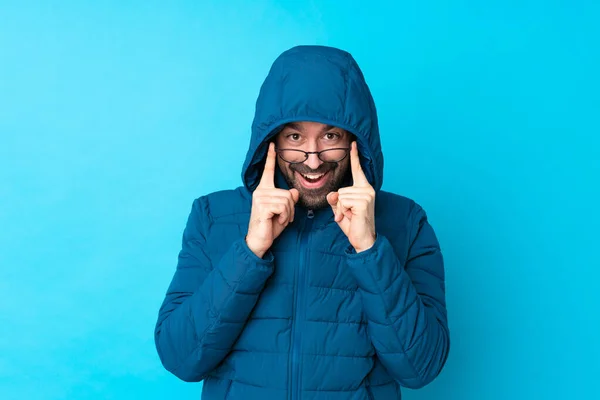 Man Draagt Winterjas Houdt Een Afhaalkoffie Geïsoleerde Blauwe Achtergrond Met — Stockfoto