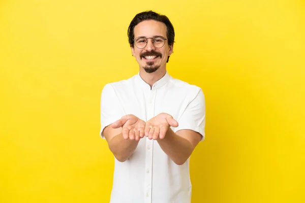 Joven Hombre Caucásico Aislado Sobre Fondo Amarillo Sosteniendo Espacio Copia — Foto de Stock