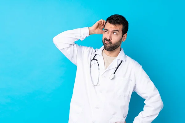 Jovem Caucasiano Sobre Fundo Isolado Vestindo Vestido Médico Tendo Dúvidas — Fotografia de Stock