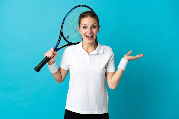 衝撃的な表情で青の背景に隔離された若い女性テニス選手 — ストック写真
