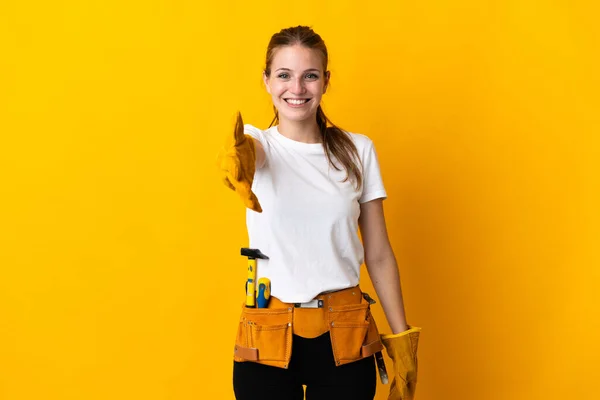年轻的电工妇女被隔离在黄色的背景下 与人握手 好不容易才合上了 — 图库照片