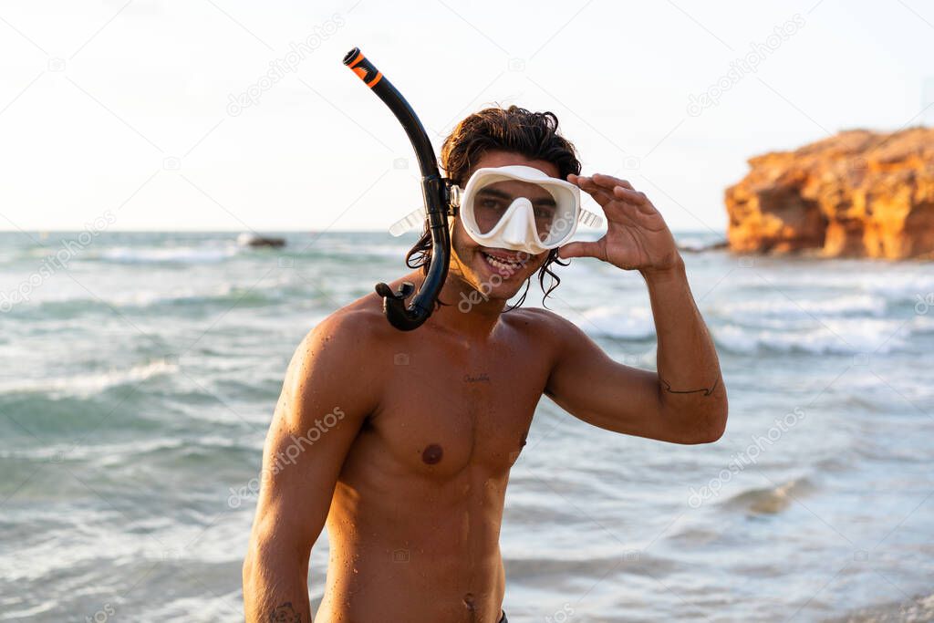 Young caucasian man getting ready to dive into the sea