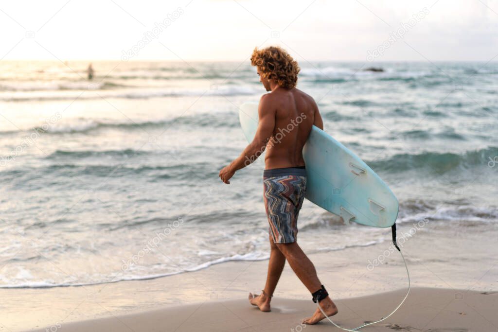 Young caucasian man get up early to  doing surf at sunrise