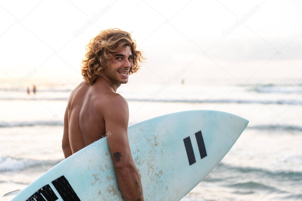 Young caucasian man get up early to  doing surf at sunrise