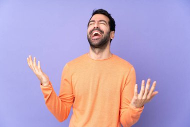 Kafkasyalı yakışıklı bir adam soyutlanmış mor arka planda gülümsüyor.