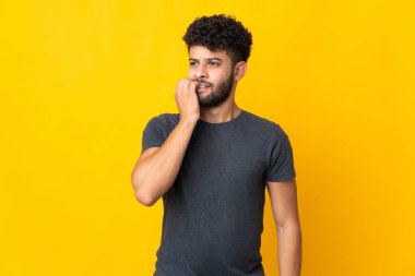 Sarı arka planda izole edilmiş genç Faslı adam biraz gergin.