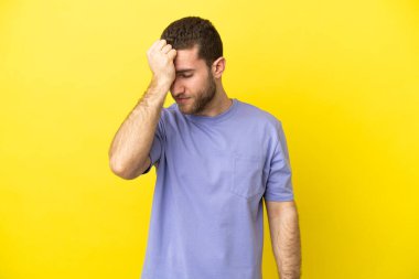Sarışın yakışıklı, soyutlanmış, sarı arka planlı, baş ağrısı olan bir adam.