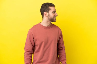 Sarışın yakışıklı adam, izole edilmiş sarı arka planda.