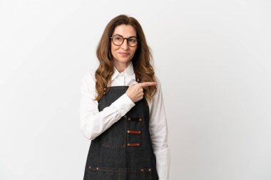 Restoran orta yaşlı garson kadın beyaz arka planda izole edilmiş bir ürün sunmak için yan tarafı işaret ediyor.