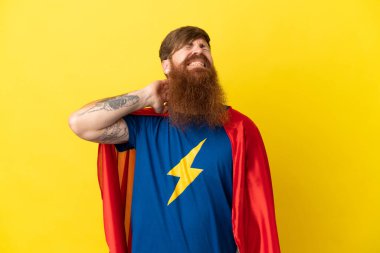 Kızıl saçlı Süper Kahraman sarı arka planda izole edilmiş, boyun ağrısı var.