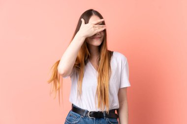 Pembe arka planda izole edilmiş, gözleri elle kaplanmış beyaz bir kadın. Bir şey görmek istemiyorum.