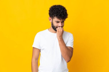 Genç Faslı adamın sarı arka planda izole edilmiş şüpheleri var.