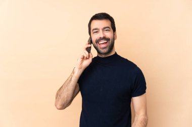 Kafkasyalı yakışıklı bir adam izole edilmiş arka planda cep telefonuyla sohbet ediyor.