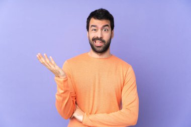 Kafkasyalı yakışıklı, soyutlanmış mor arka planda şüpheli davranışlar sergiliyor.