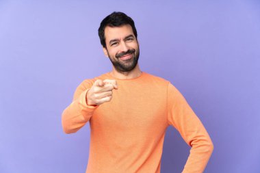 Mor arka planda beyaz tenli yakışıklı bir adam kendine güvenen bir ifadeyle seni işaret ediyor.