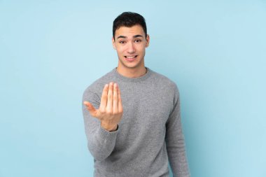 Beyaz tenli yakışıklı adam, mavi arka planda soyutlanmış ve davet edilmişti.