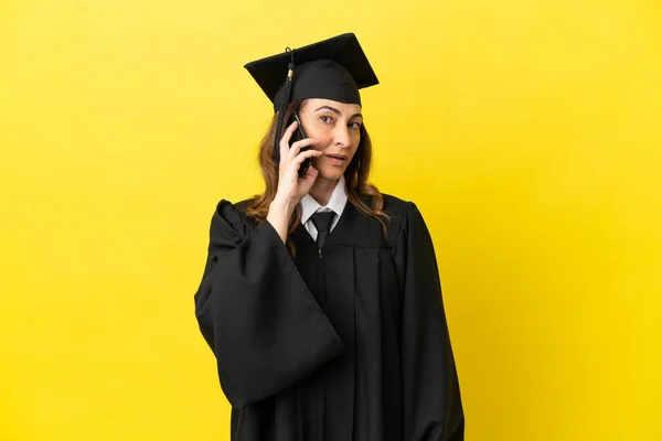 Middle Aged University Graduate Isolated Yellow Background Keeping Conversation Mobile — Stock Photo, Image