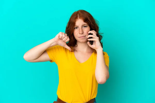 Teenager Načervenalé Žena Pomocí Mobilního Telefonu Izolované Modrém Pozadí Ukazující — Stock fotografie