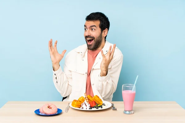 Mannen Vid Ett Bord Med Frukostvåfflor Och Milkshake Med Överraskande — Stockfoto