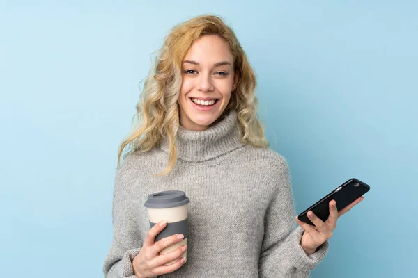 Jovem Loira Vestindo Uma Camisola Isolada Fundo Azul Segurando Café — Fotografia de Stock