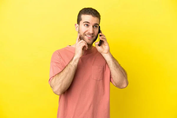 Handsome Blonde Man Using Mobile Phone Isolated Background Thinking Idea — Stock Photo, Image
