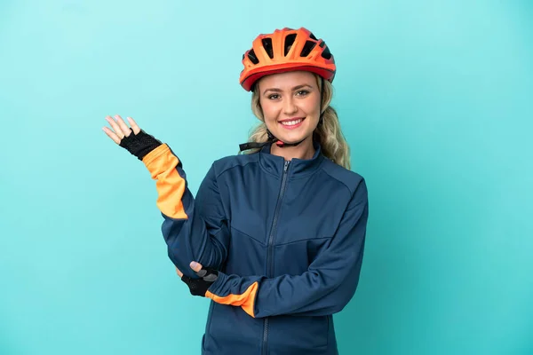 Νεαρή Ποδηλάτισσα Γυναίκα Απομονωμένη Μπλε Φόντο Απλώνει Χέρια Στο Πλάι — Φωτογραφία Αρχείου