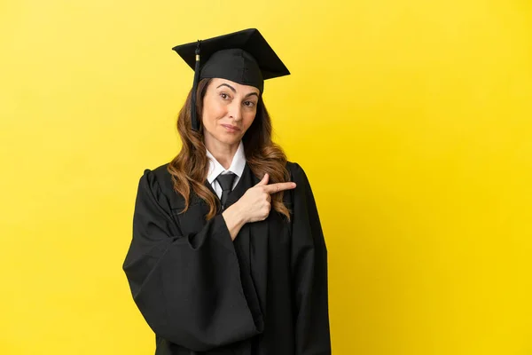 Middle Aged University Graduate Isolated Yellow Background Pointing Side Present — Stock Photo, Image