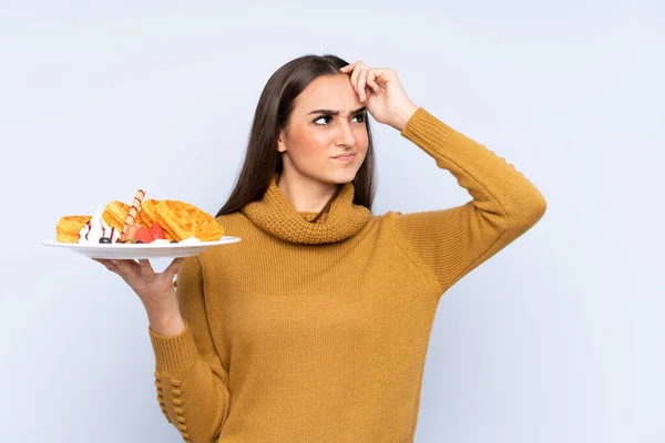 Young Caucasian Woman Holding Waffles Isolated Blue Background Having Doubts — Stock Photo, Image
