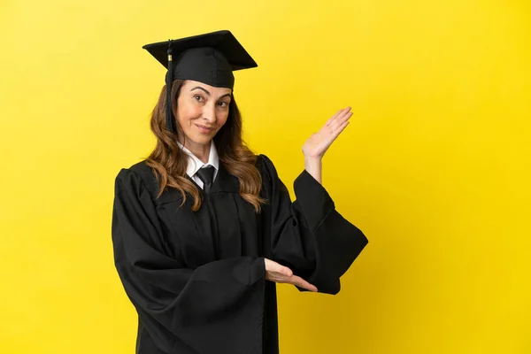 Middle Aged University Graduate Isolated Yellow Background Extending Hands Side — Stock Photo, Image