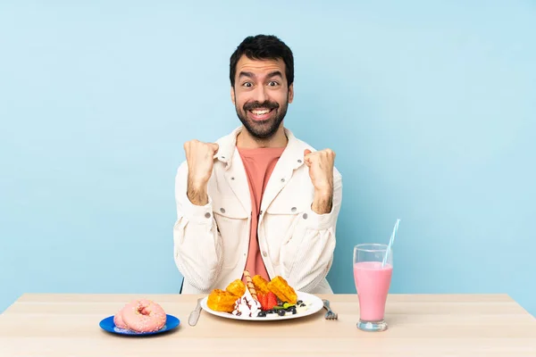 Masada Kahvaltılık Waffle Yiyen Milkshake Içen Bir Adam Galibiyeti Kutluyor — Stok fotoğraf